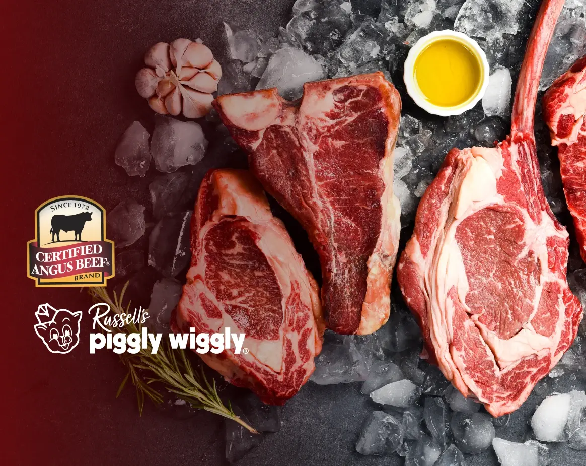 Certified Angus Beef ribeye and T bone steaks on ice with garlic and olive oil at Russell’s Piggly Wiggly