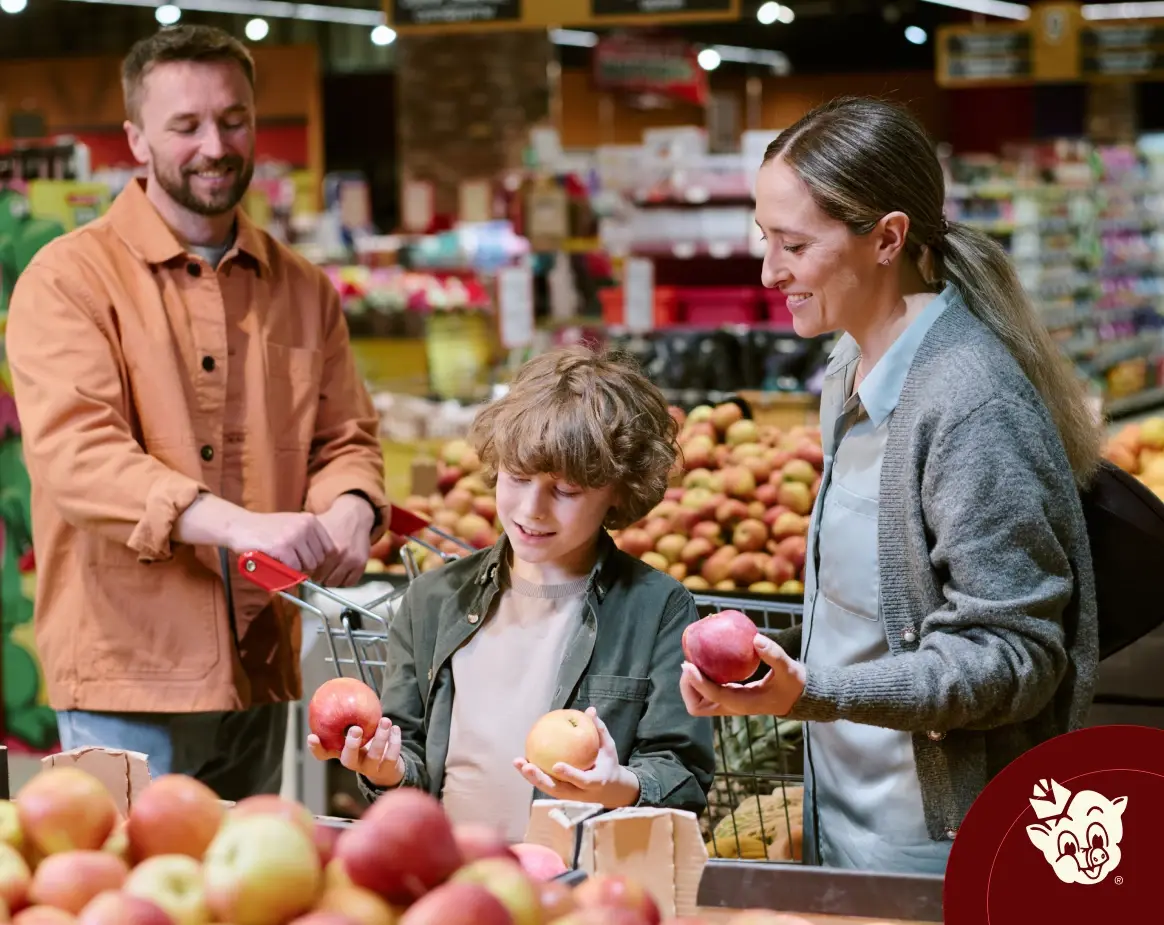 Family selecting fresh apples in the produce section at Russell’s Piggly Wiggly grocery store